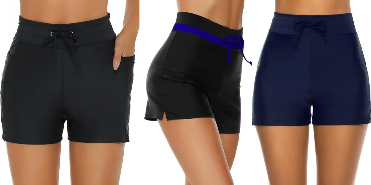 A lineup of three different pairs of women's board shorts. The first pair is black with side pockets and a drawstring waist. The middle pair is black with a blue waistband and a side slit. The third pair is navy blue with a drawstring waist. All are modeled on tan-skinned torsos.