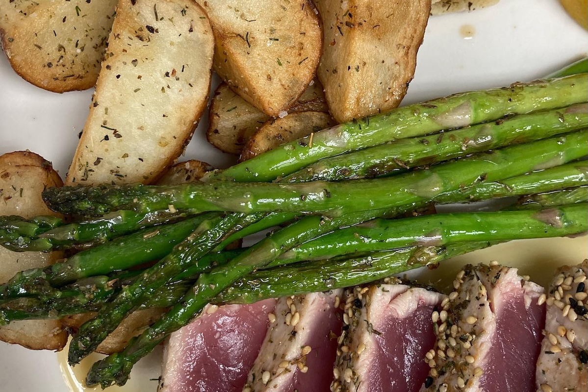 Roasted baby potatoes, asparagus and pieces of fish.