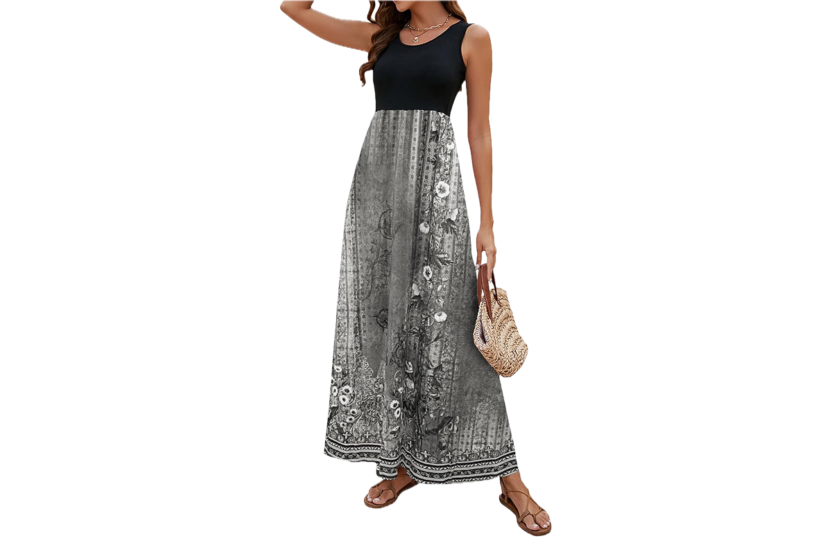 A woman wearing a long dress. The dress is sleeveless with a solid black top and a soft grey bottom.