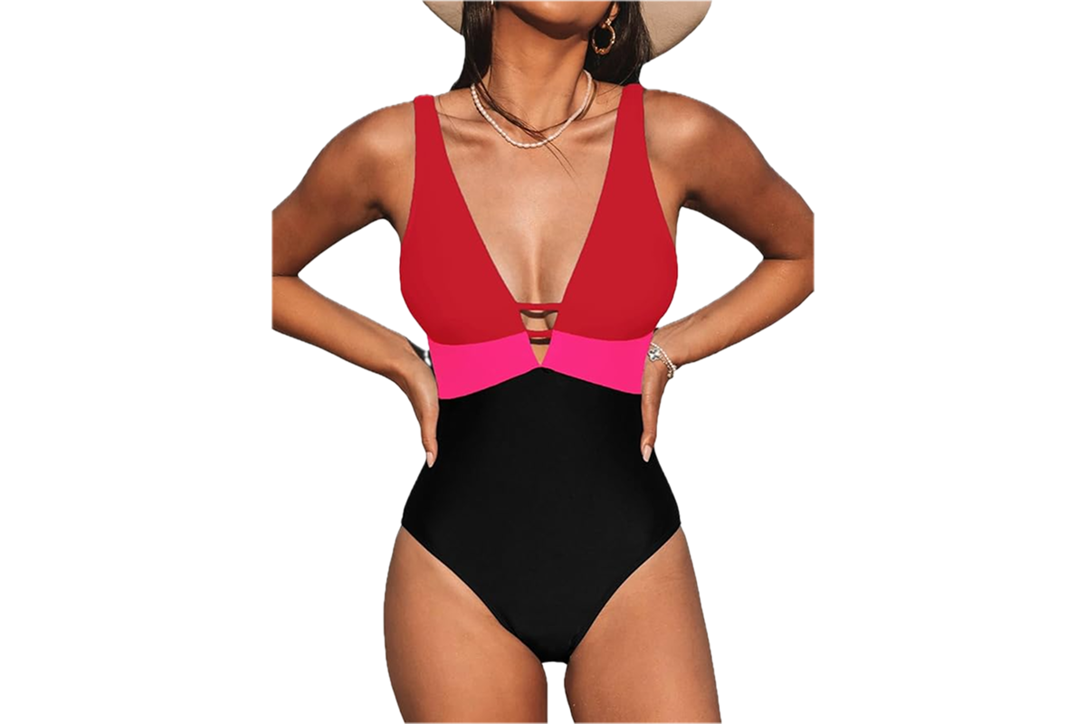 A woman wearing a bathing suit with a red v neck chest, a pink color block band at the waist and black bottom.