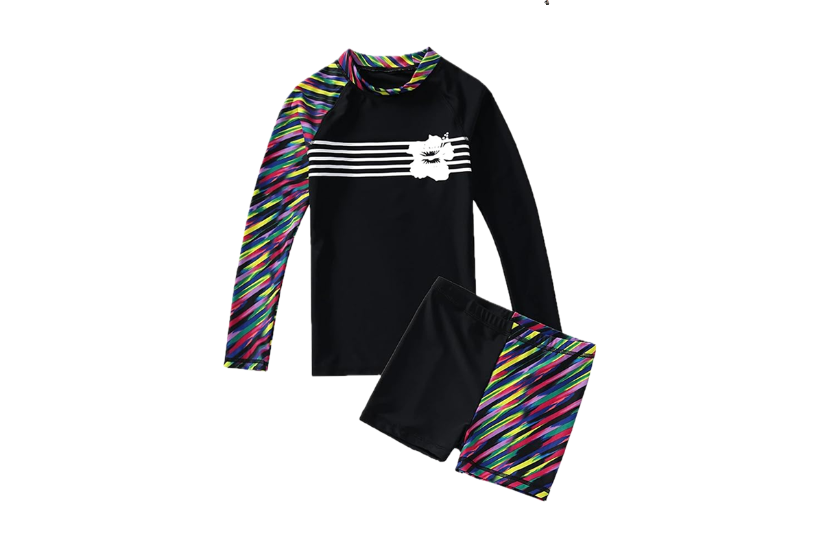 A long-sleeve black swim shirt with a multicolored design—featuring pink, yellow, blue, and white—on the right sleeve and collar, and five white stripes with a white flower running across the chest. Below it are matching swim trunks.