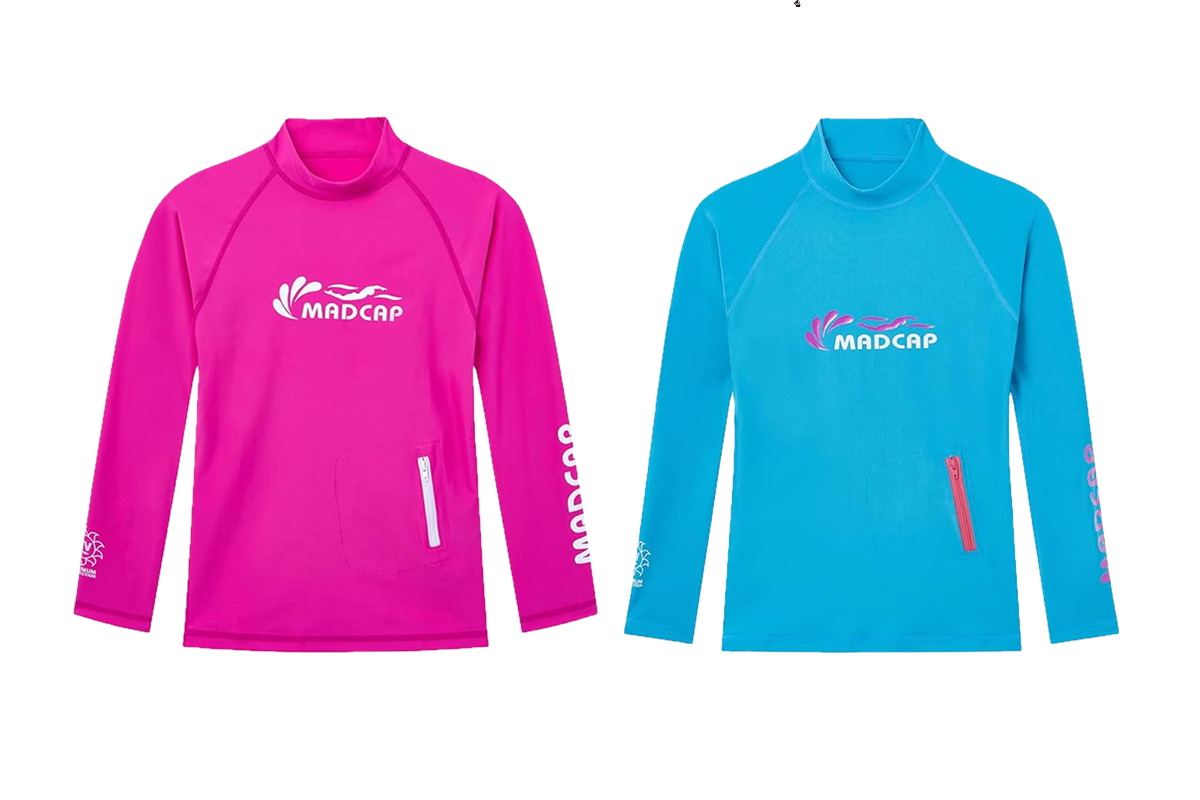 This image shows the front and back views of a bright blue long-sleeve rash guard with a high collar. Perfect as one of the UV tops for teens, it features "MADCAP" in white on the front and a small pink zipper pocket. The back displays the logo in the upper center, and the left sleeve has pink text.
