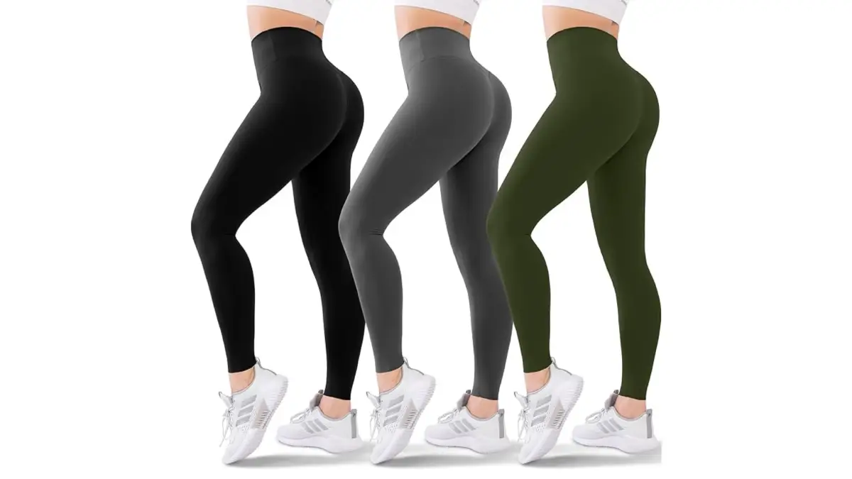 Image of three pairs of high-waisted yoga pants worn by a model who is cropped from the waist down. The leggings are displayed in three colors: black, gray, and olive green. The model pairs the yoga pants with white athletic shoes.