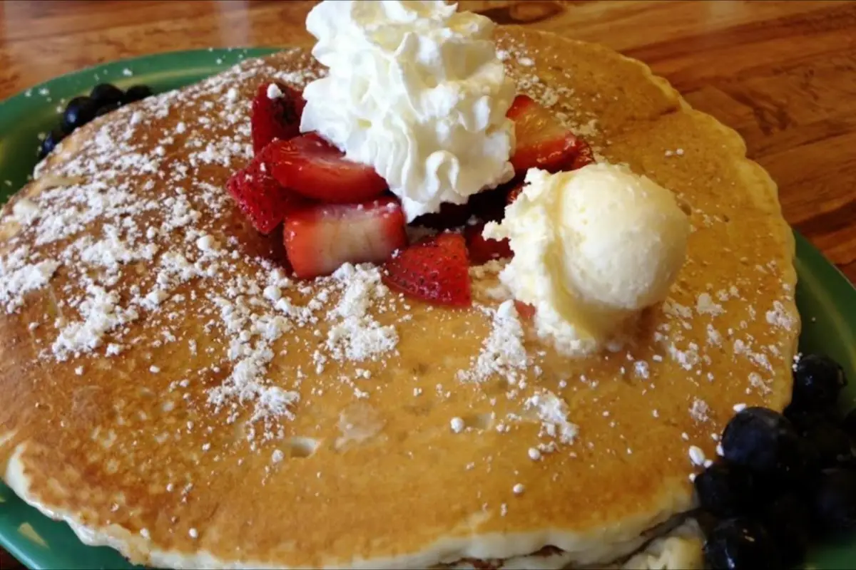 Stack of pancakes with strawberries, whipped cream and butter from the Hawaii Island restaurant Hawaiian Style Restaurant serving breakfast
