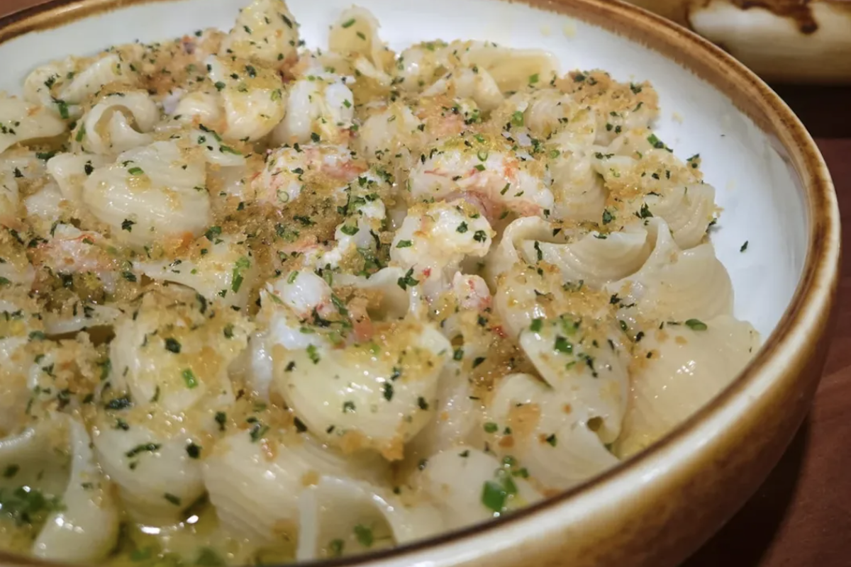 A pasta dish topped with finely chopped herbs.