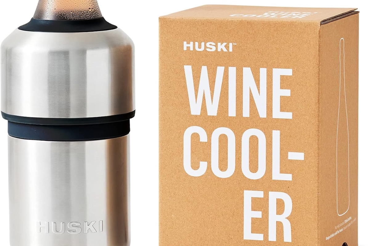 A close up of a stainless steel wine chiller with a bottle in it and a box that says "Huski Wine Cool-er".