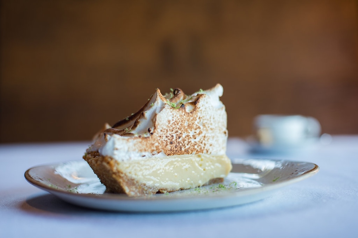 A slice of key lime pie topped with toasted meringue.