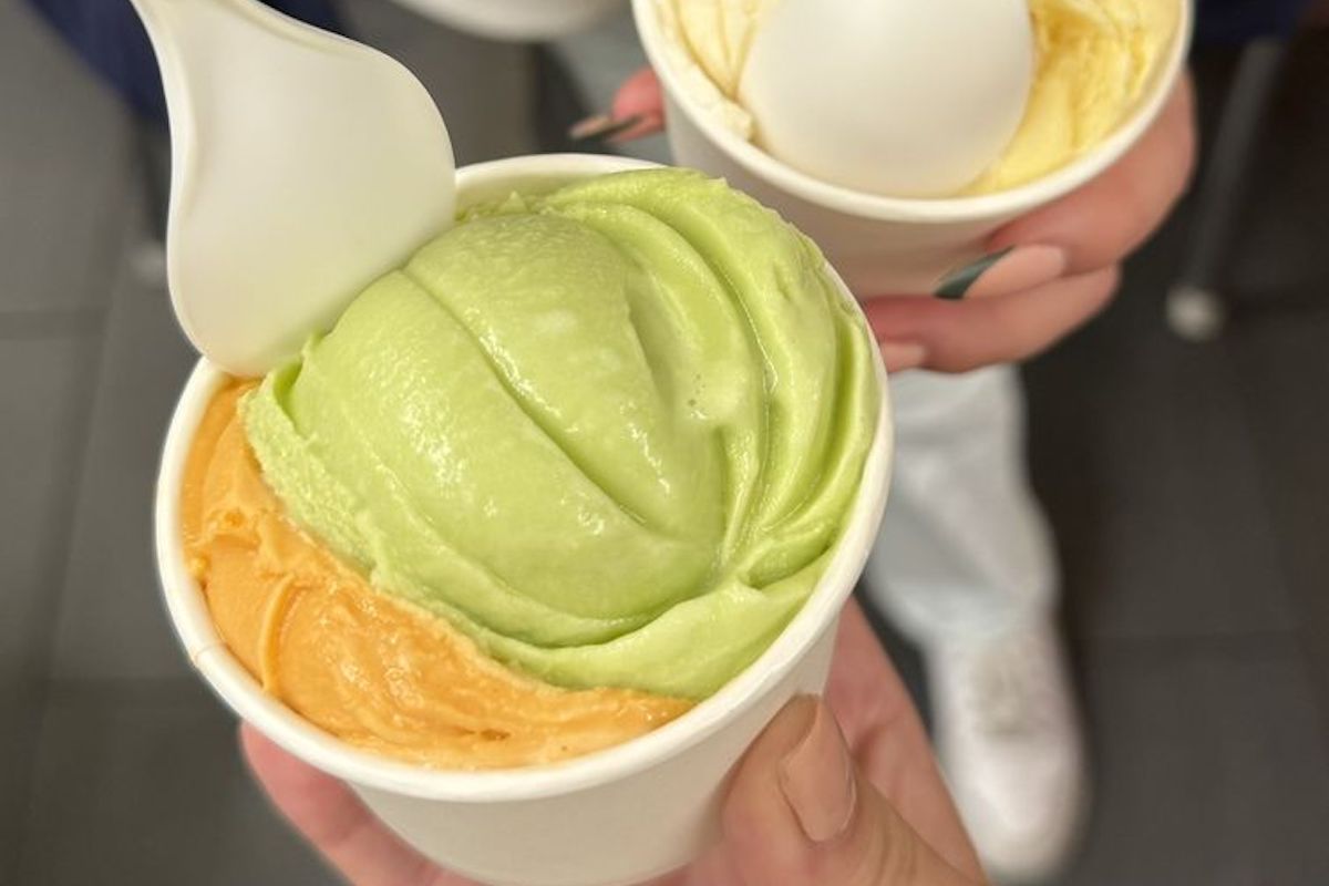 People holding cups of Durian Lychee Pandan and Thai tea ice cream.