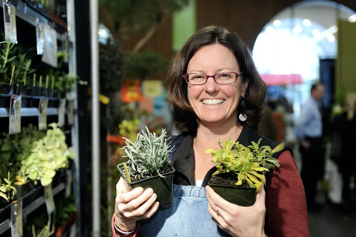 Woman holds two potted succulents at the San Francisco Bay Flower and Garden Show at the Alameda Fairgrounds in Pleasanton, California.