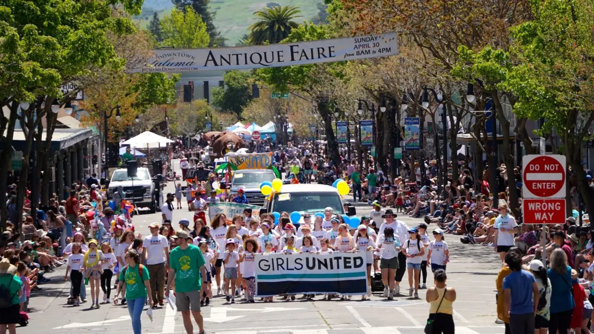 Group of school-age girls march in the Butter and Eggs Day Parade in downtown Petaluma, California.
