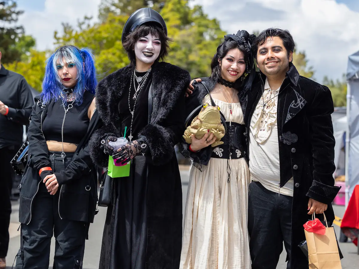 Four friends in goth fashion smile and pose for World Goth Day in Alameda, California