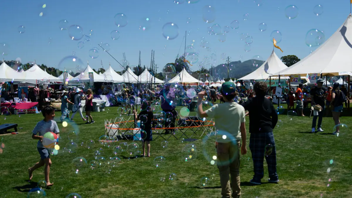 Kids stand around bubbles and activities at the Mill Valley Music Festival