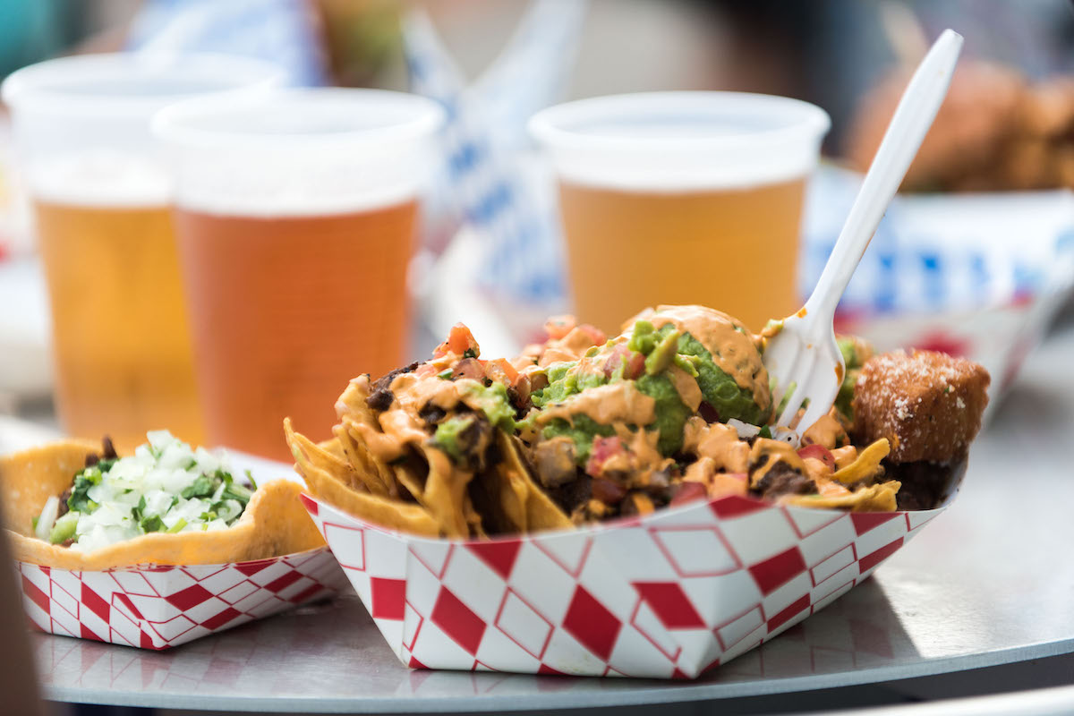 A platter with loaded fries and beers at Vegan Street Fair in Alameda, California