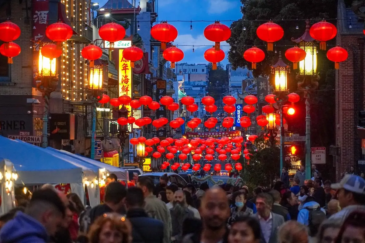 Lanterns light up a crowd of people and vendor tents below in San Francisco's Chinatown Night Market.