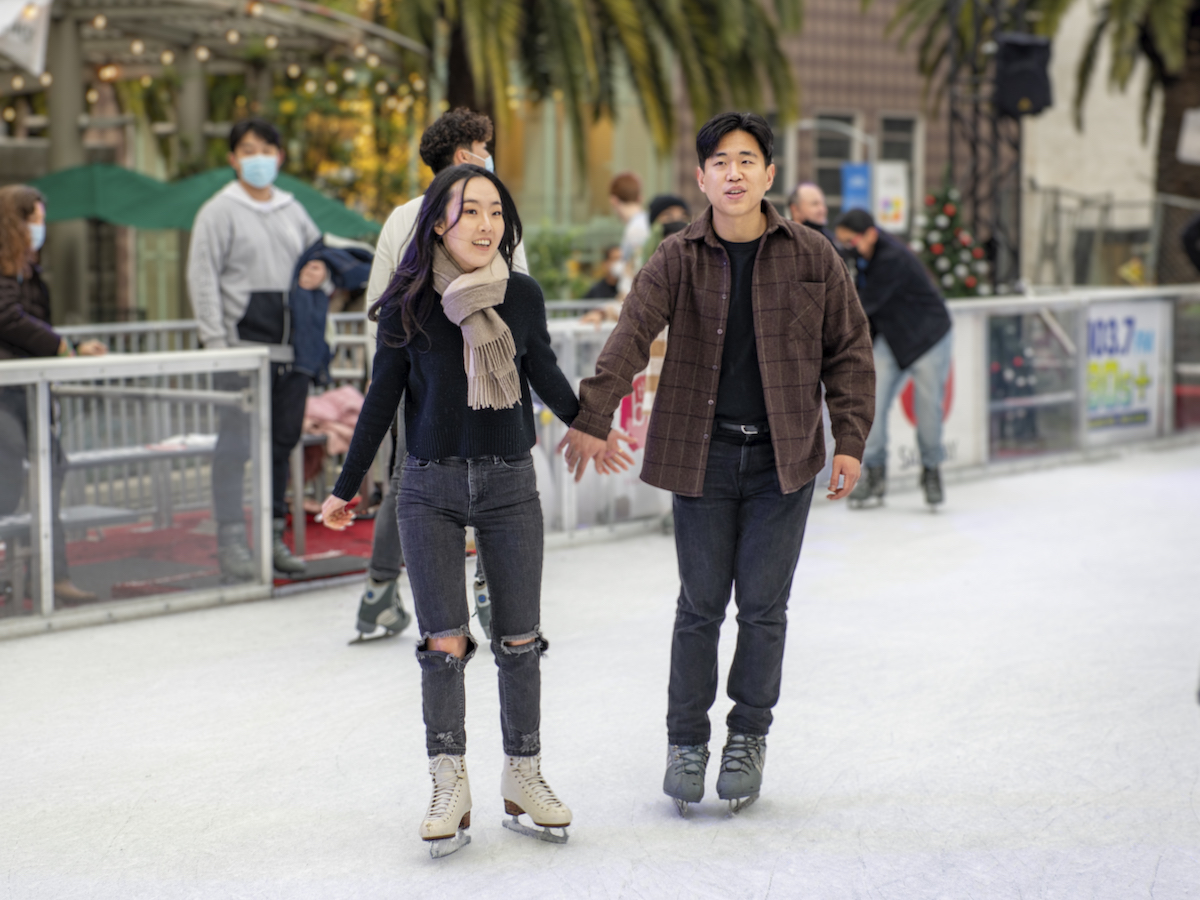 Couple holding hands while ice skating on San Francisco's Union Square Holiday Ice Rink