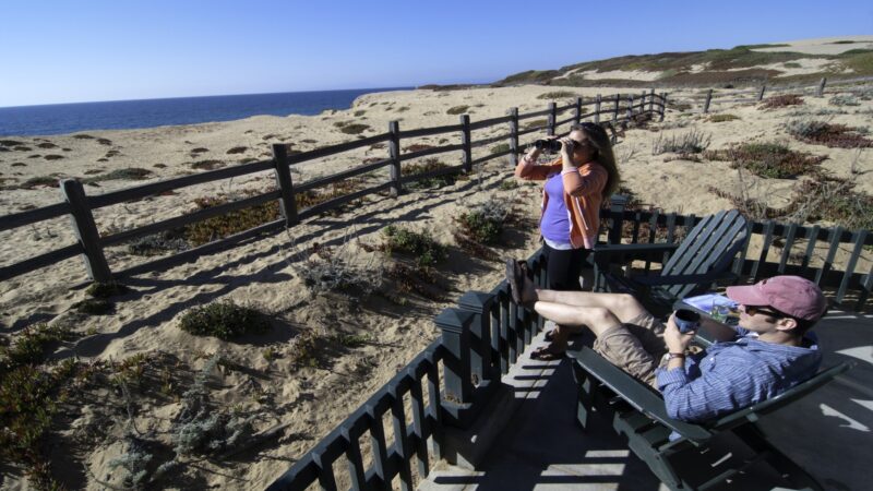 Couple watches the ocean from their balcony at the Sanctuary Beach Resort in Marina, California.