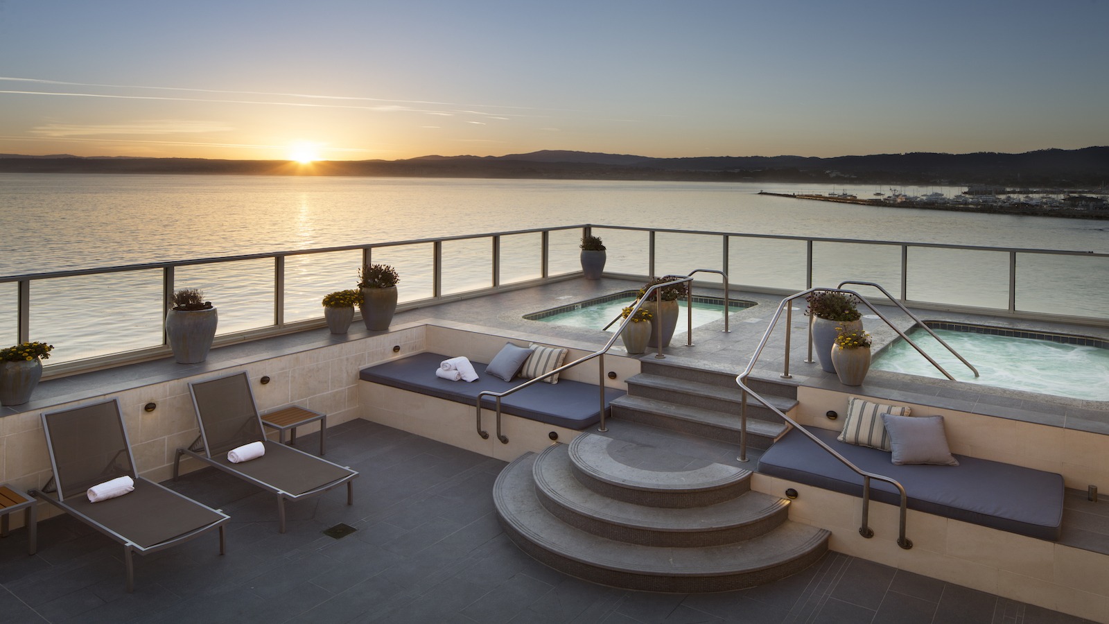 The best wellness and spa hotels in Monterey. Spa and pool chairs on a bay-facing patio at the Monterey Plaza Hotel and Spa in Monterey, California.