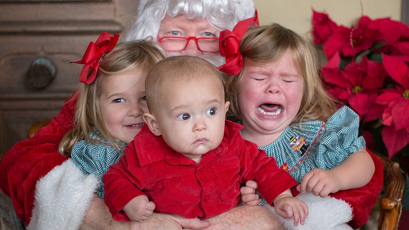 Crying children held by Santa Claus at Costeaux French Bakery's Breakfast with Santa Claus event in Sonoma County, California