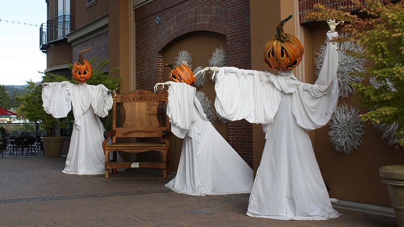 Three ghosts with pumpkin heads at Downtown Napa's Halloween event.