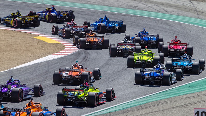 Race cars round the track at Firestone Grand Prix in Monterey, California.