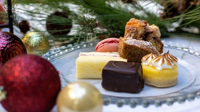 Stack of pastries, desserts and cookies in front of pine tree at Hotel Healdsburg's holiday tea spread in Sonoma County, California
