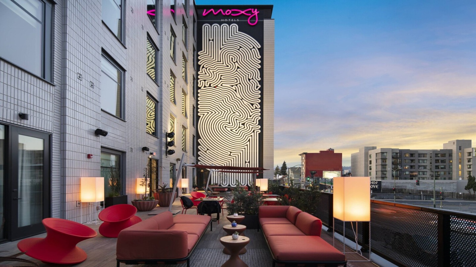 Outdoor roof patio at Moxy Oakland with couches and lamps, a great hip hotel for group travel