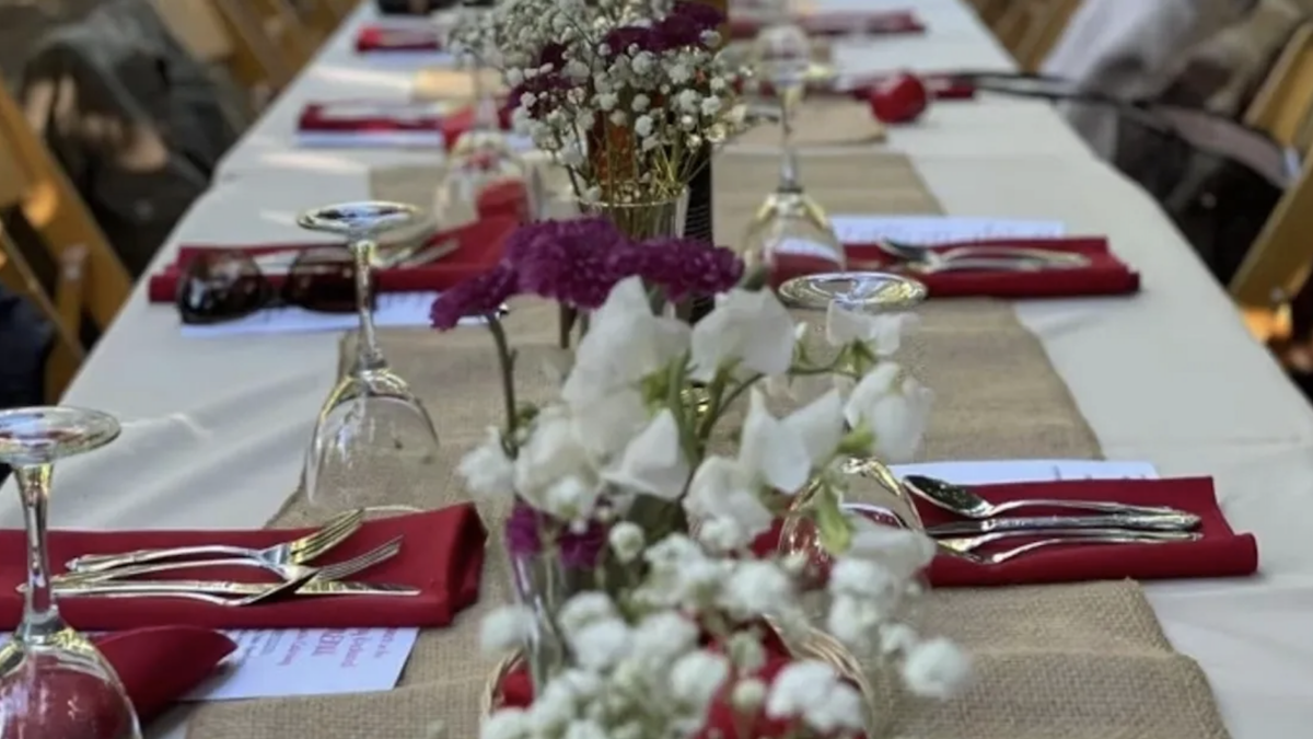 A dinner is set with silverware and flowers at Gilroy Garlic Festival, presenting Nashville Songwriters in Gilroy, California