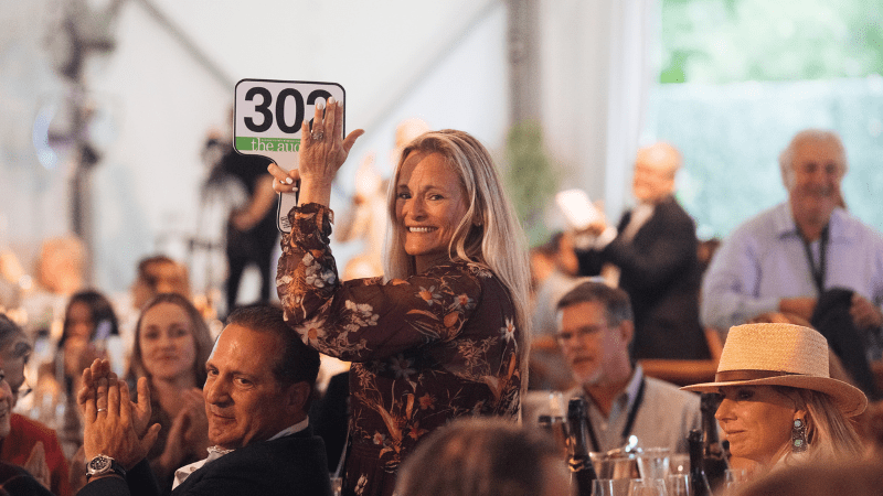 Woman claps at live auction for Sonoma County Wine Auction in Healdsburg, California