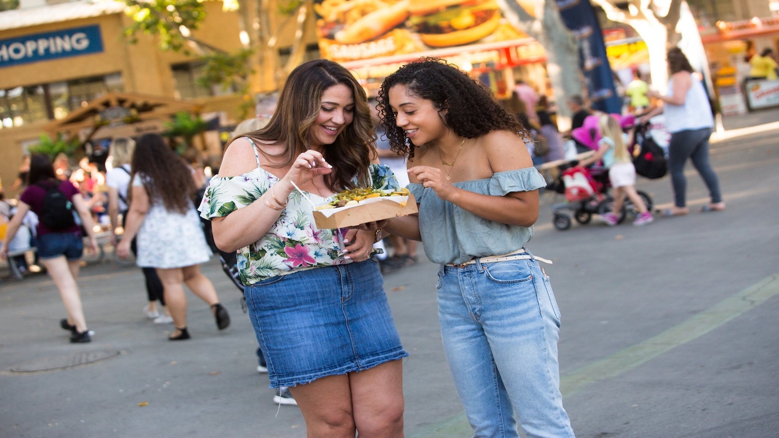 Two women share food at Alameda County Fair in East Bay.