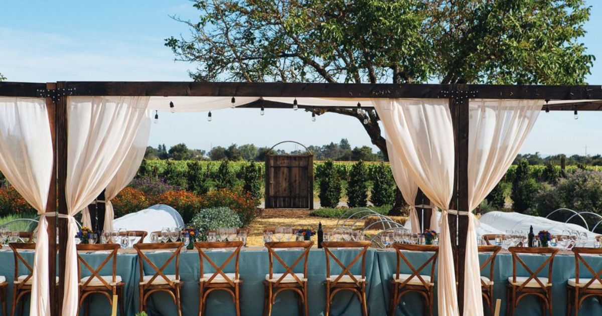 A long table set outdoors with wine glasses at the Kendall Jackson Wine Estate Gardens.