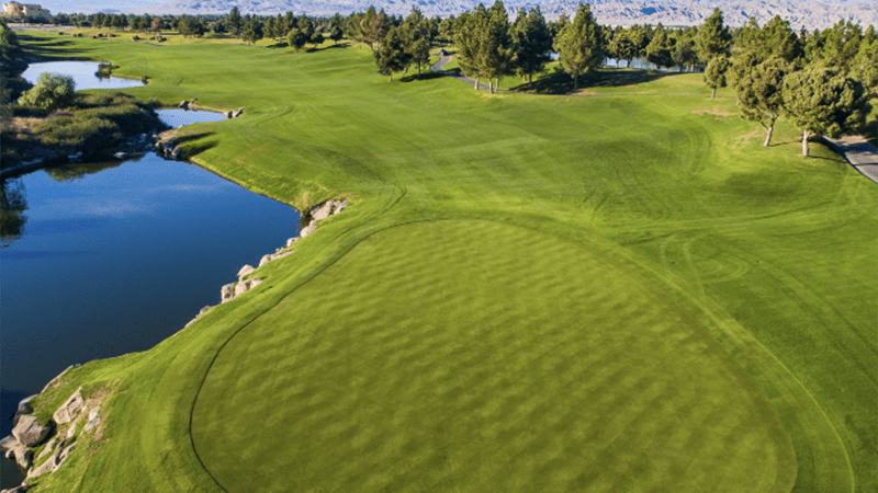 A wide golfing green and pond as seen from above at Classic Club