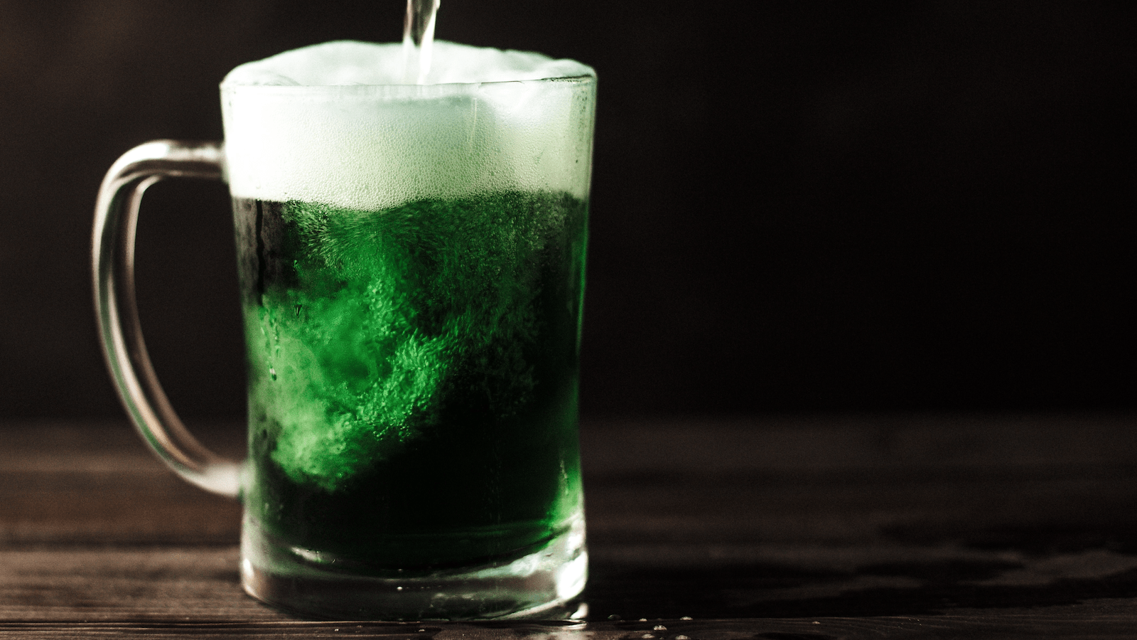 Green beer being poured into pint glass