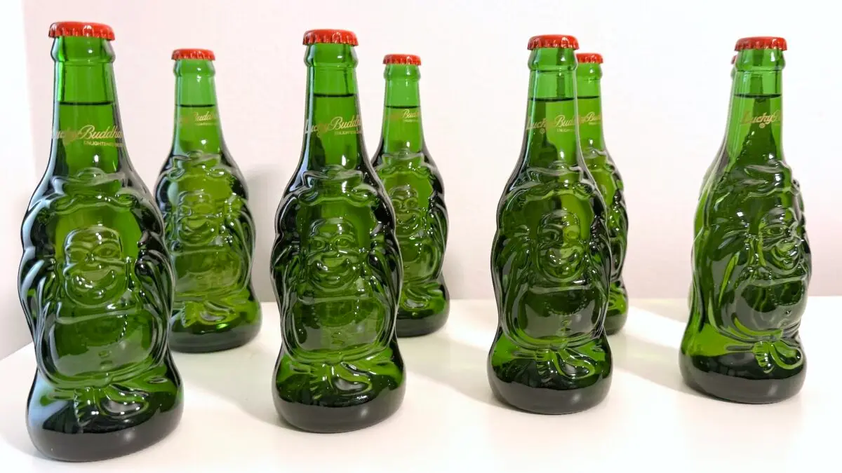 Line of Buddha Beer bottles on white table