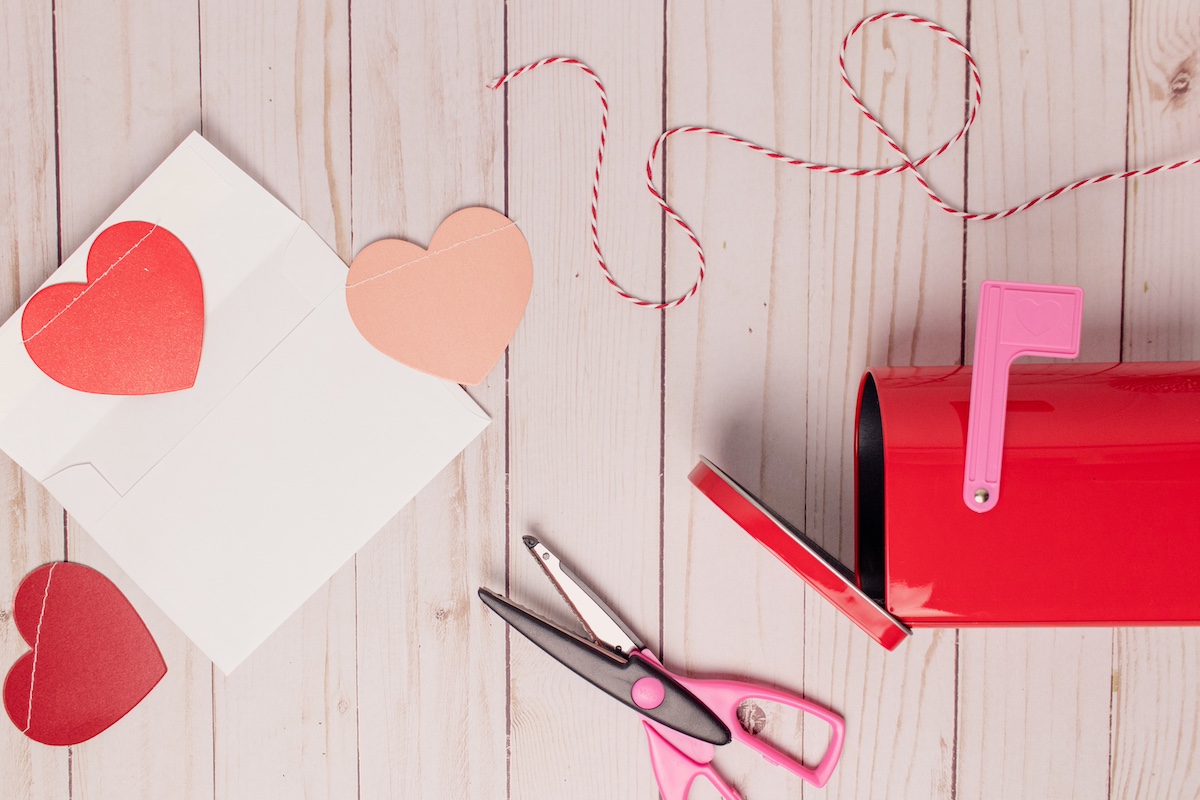 Valentine's arts and crafts lie on table next to pink mail box