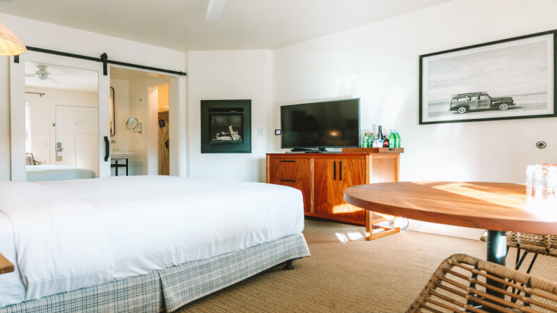 Hotel room with bed, table, TV and fire place at the Getaway (now known as Le Petit Pali) in Monterey, California