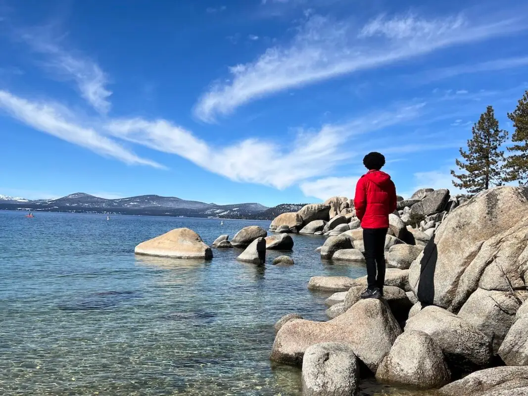 Jordan stands on rocks at shores of Lake Tahoe, California