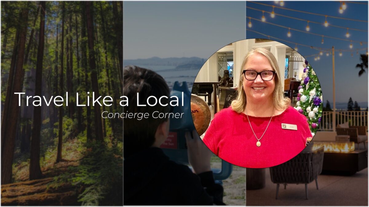 A banner image with the title "Travel Like a Local – Concierge Corner." The background features three scenes: a forest, a person using a binocular viewer, and a cozy outdoor seating area with string lights. A circular inset shows a smiling woman in glasses and a red top, inviting you to visit East Bay.