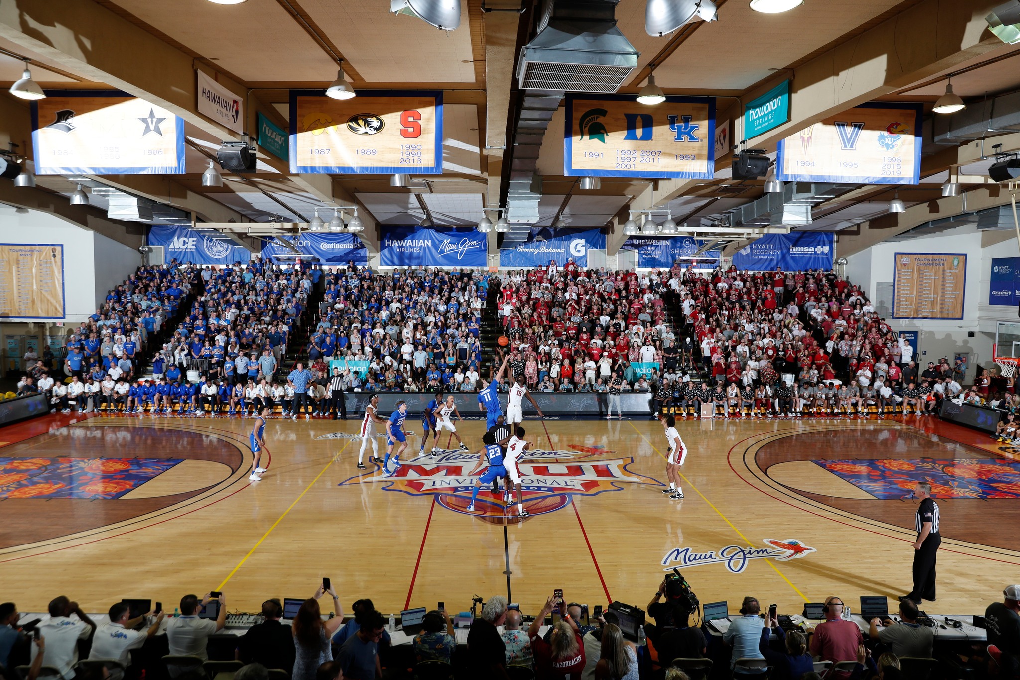 A gym filled with a large crowd watches a basketball game for the Maui Invitational.