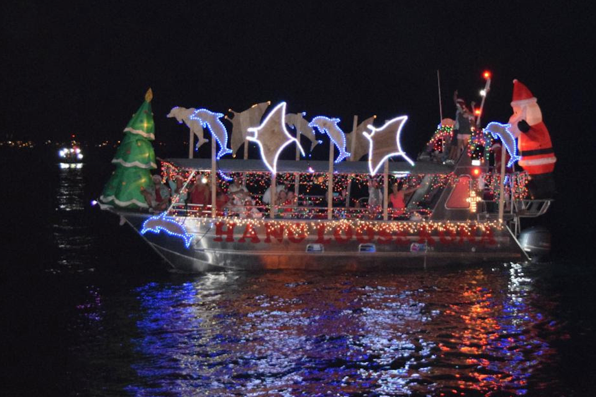 A boat with a light display depicting manta rays and dolphins.