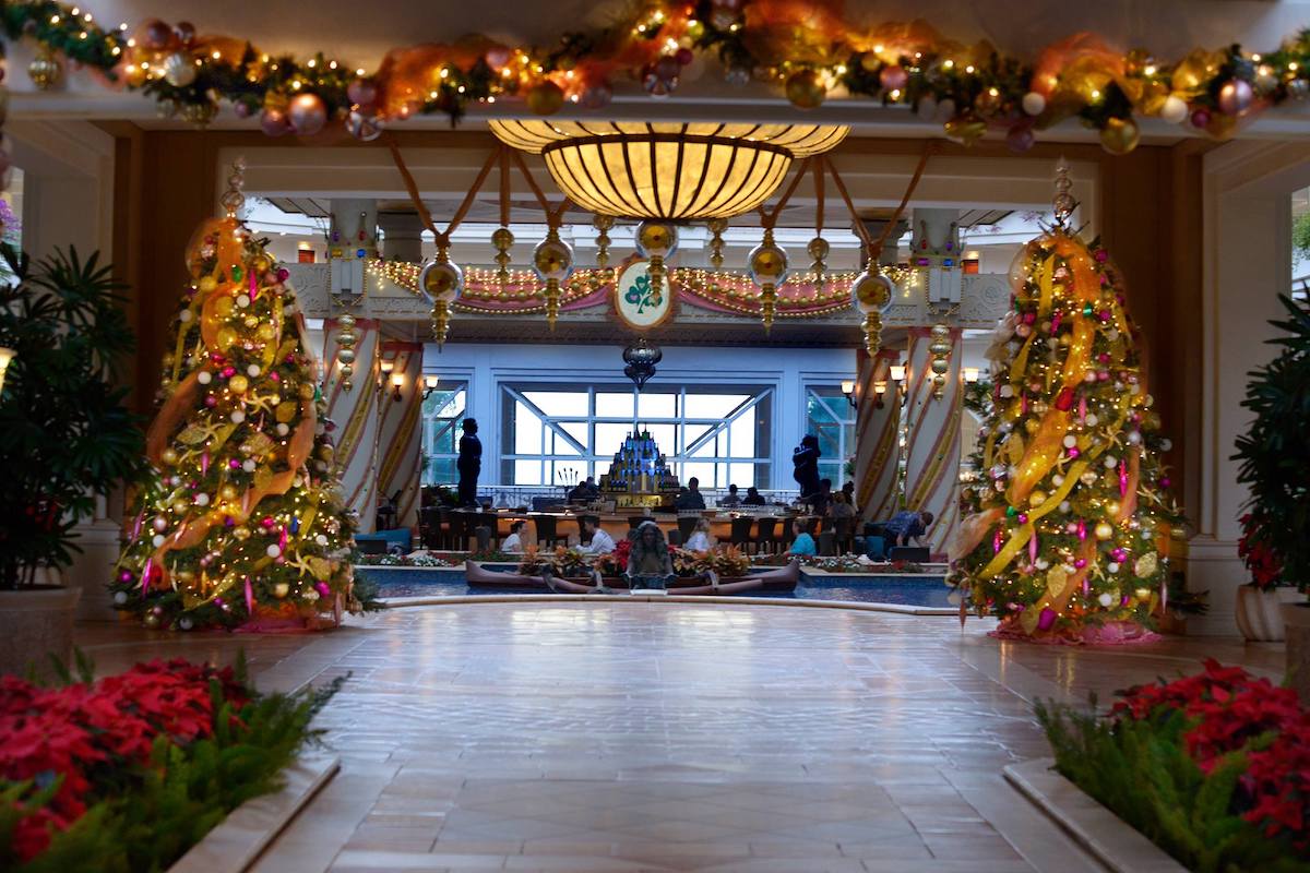 A hotel lobby with Christmas trees, lights and garland.