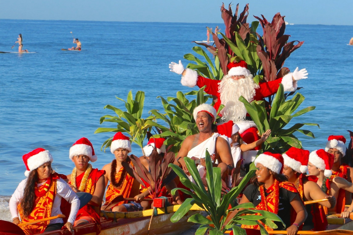 Santa and many people wearing santa hats for Outrigger.