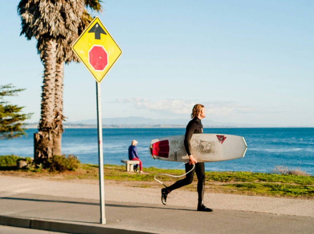 Surfer walking in Santa Cruz with board by ocean