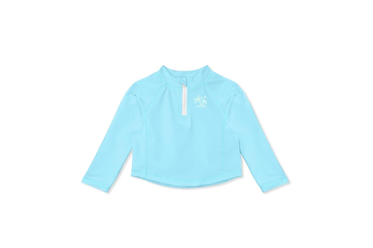 A light blue shirt with long sleeves, a white half zipper and a white design on the upper left chest.