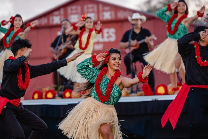 A group of men and women perform hula dance.