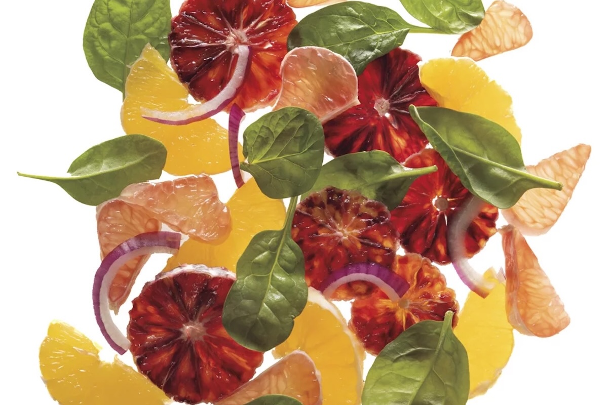 A collage of blood orange, orange, basil leaves and red onion.