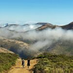 Wisps of fog fill sneak through the valleys of the Marin Headlands. Seen from the Coastal Trail on Coyote Ridge, north of Tennessee Valley. Wolf Ridge and Hill 88 are on the right, and San Francisco is seen in the gap in the hills at the top of McCullough Road. Golden Gate National Recreation Area (GGNRA), California.