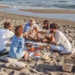 A group of friends having a picnic on a beach.