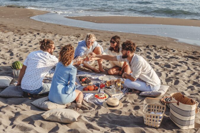 A group of friends having a picnic on a beach.