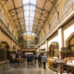 An interior shot of the SF Ferry Building, with tall vaulted ceilings and people walking to visit the various shops.