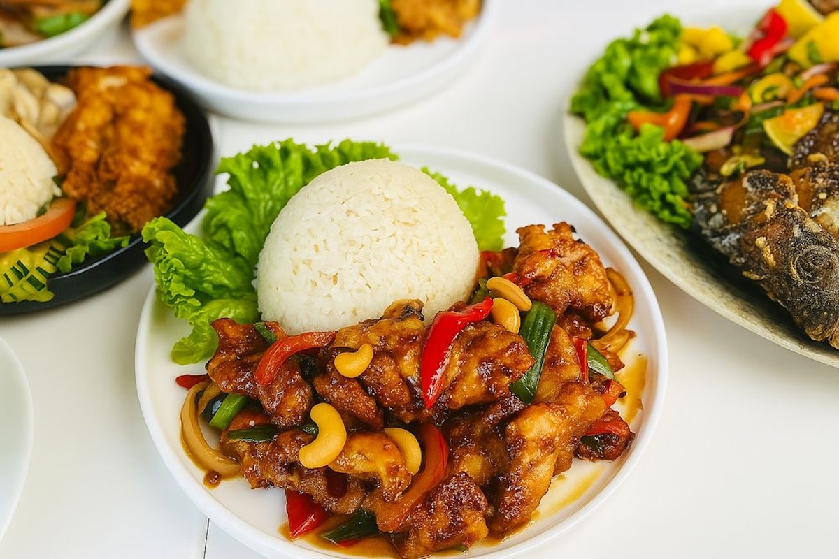 Plates of food, including a bowl with a scoop of rice, a piece of lettuce and a Thai chicken dish.
